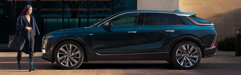 A sleek, dark-colored luxury SUV parked outside a modern building.