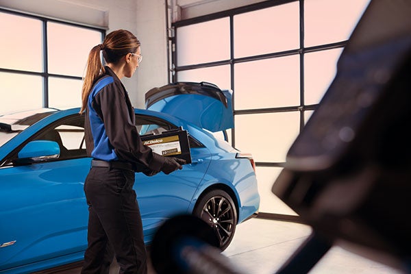 service tech inspecting vehicle Alexander Cadillac in Oxnard CA